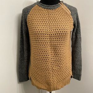 Open-knit tan sweater with zipper accent and gray sleeves